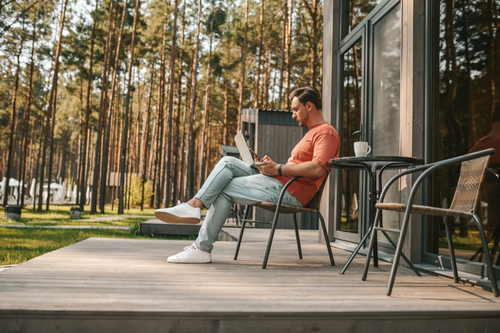 work-from-home-young-man-with-laptop-sitting-outside-working-online